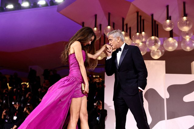 Cast member George Clooney kisses the hand of his wife Amal Clooney on the red carpet for the screening of ”Jay Kelly” on August 28, 2025. (Photo by Yara Nardi/Reuters)