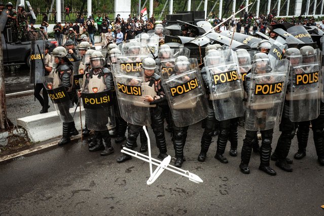A white folding chair is thrown at police during a demonstration demanding the dissolution of parliament on a street in front of the House of Representatives parliament building in Jakarta on August 25, 2025. (Photo by Yasuyoshi Chiba/AFP Photo)