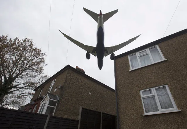 An aircraft  passes over houses as it lands at Heathrow Airport near London, Britain, December 11, 2015. (Photo by Neil Hall/Reuters)