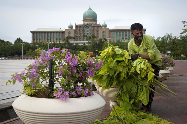 A worker cleans in front of the prime minister's office building in Putrajaya, Malaysia, Friday, October 23, 2020. Malaysian opposition leader Anwar Ibrahim said Friday he was concerned about reports that Prime Minister Muhyiddin Yassi may invoke emergency laws to suspend Parliament and stymie bids to oust his government. (Photo by Vincent Thian/AP Photo)
