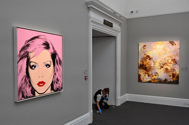 An employee workjs near artworks entitled “Debbie Harry” by Andy Warhol, during a photocall at Sotheby's auction house in central London on February 22, 2023. The painting is expected to realise in the region of USD 4-6 million dollars (EUR 4-7 million euros, GBP 3-5 million pounds) at auction in March. (Photo by Justin Tallis/AFP Photo)