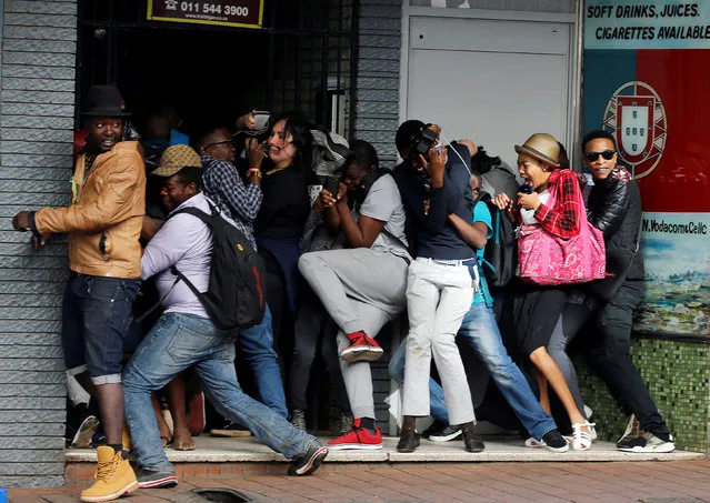 Students demanding free education react as they are fired at by riot police officers during a protest outside the University of the Witwatersrand at Braamfontein, in Johannesburg, South Africa, October 10,2016. (Photo by Siphiwe Sibeko/Reuters)