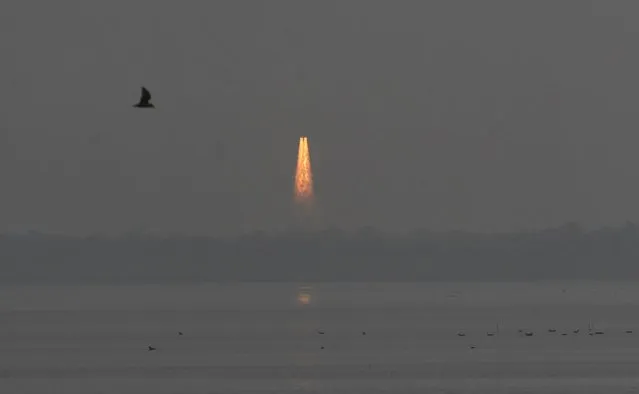 Indian Space Research Organisation's Geosynchronous Satellite Launch Vehicle (GSLV Mark-III) rocket lifts off carrying CARE (Crew Module Atmospheeric Re-entry Experiment) from the east coast island of Sriharikota, India, Thursday December 18, 2014. India successfully launched its heaviest rocket carrying an experimental crew module from Sriharikota in the southern state of Andhra Pradesh, according to ISRO. (Photo by Arun Sankar K./AP Photo)