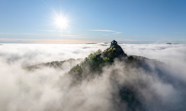 An aerial photograph taken with a drone shows fog drifting around the Castle of Salgo near Salgotarjan, Hungary, in the early hours of 19 April 2025. (Photo by Péter Komka/EPA/EFE)