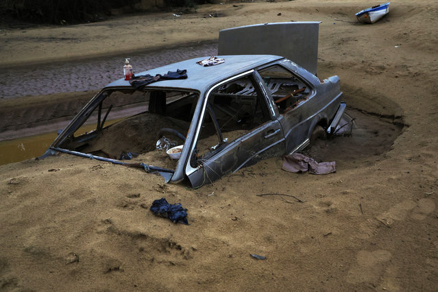 A buried car is pictured in Ilha Grande dos Marinheiros, Porto Alegre, Rio Grande do Sul State, Brazil, on June 17, 2024. Tons of rubbish still litter the streets of Porto Alegre after the floods that hit the city. (Photo by Sílvio Ávila/AFP Photo)