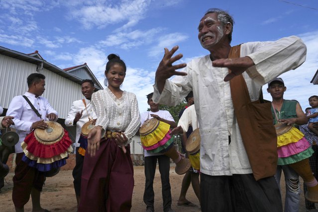 An elderly man joins dancers participating in the He Neak Ta rituals in Phum Boeung village, northwest of Phnom Penh, Cambodia, Tuesday, June 11, 2024. Cambodian villagers on Tuesday took part in a rare traditional guardian spirit ceremony praying for good fortune, rain and prosperity, as they aimed to preserve this ancient tradition. (Photo by Heng Sinith/AP Photo)
