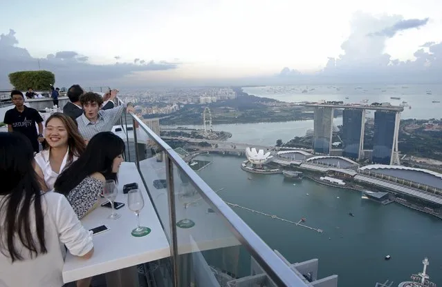 Vistors look out at the skyline from a rooftop bar in the central business district in Singapore July 24, 2015. (Photo by Edgar Su/Reuters)