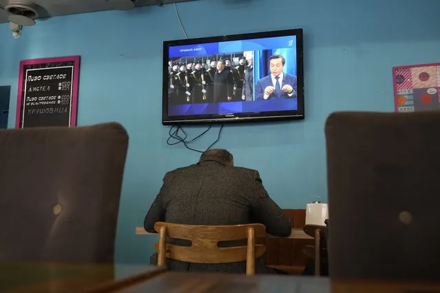 A TV screen displays Chinese President Xi Jinping attending an official welcome ceremony upon his arrival at the Vnukovo-2 government airport outside Moscow, in a cafe in St. Petersburg, Russia, Monday, March 20, 2023. (Phoot by AP Photo/Stringer)