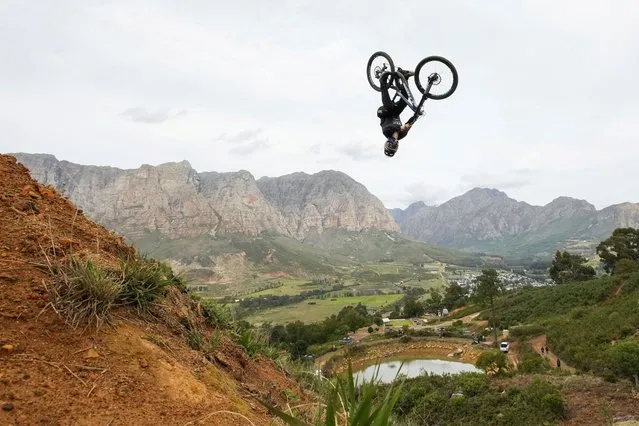Rider Szymon Godziek from Poland jumps during the Darkfest extreme freeride mountain biking event in Stellenbosch, South Africa on April 21, 2023. (Photo by Nic Bothma/Reuters)