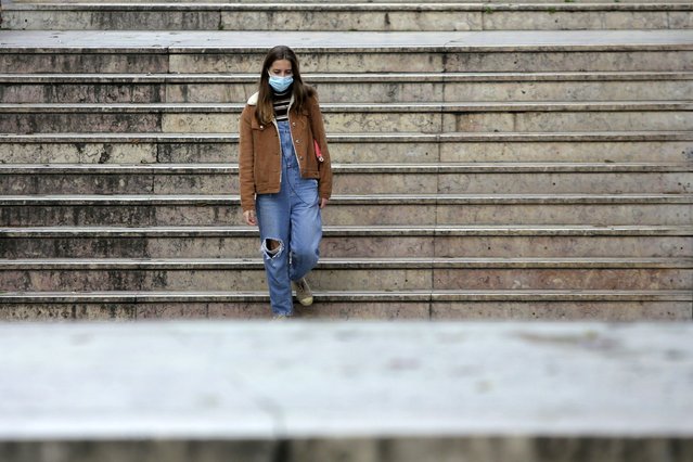 A young woman wearing a face mask enters a subway station in Lisbon, Friday, January 22, 2021. Portugal's COVID-19 surge is continuing unabated, with a new record of daily deaths, hospitalizations and patients in intensive care. (Photo by Armando Franca/AP Photo)