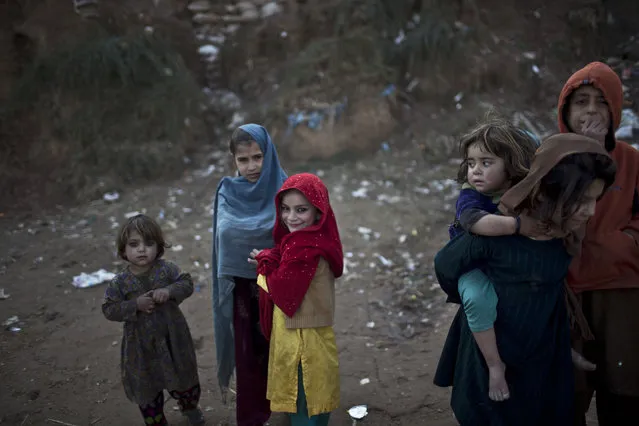 Afghan refugee children gather in a slum on the outskirts of Islamabad, Pakistan, Wednesday, January 14, 2015. (Photo by Muhammed Muheisen/AP Photo)