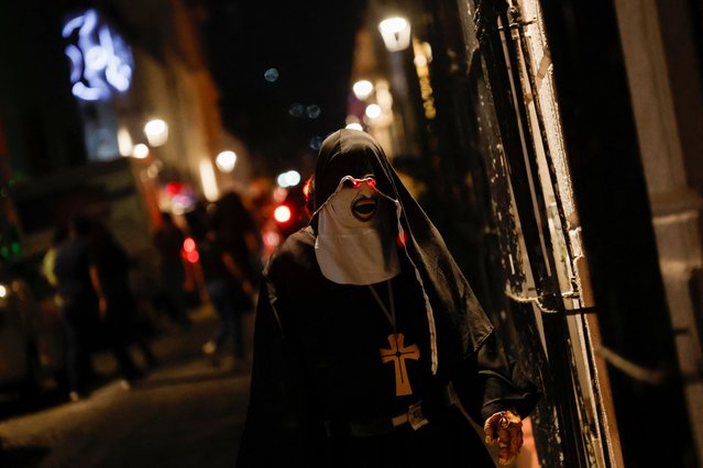 A person walks down a street dressed as the horror movie character The Nun on Halloween evening, in Monterrey Mexico on October 31, 2024. (Photo by Daniel Becerril/Reuters)