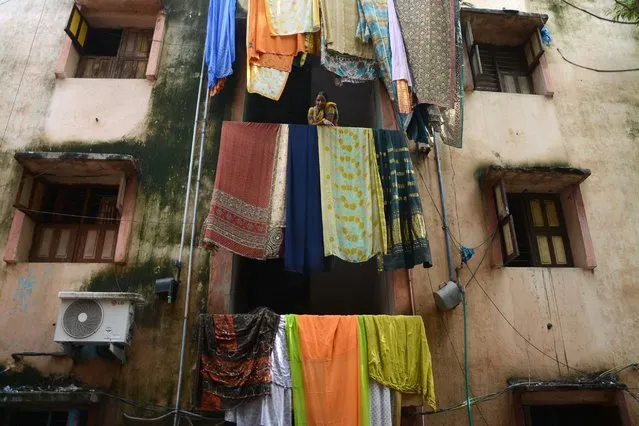 An Indian woman is surrounded by bedding hung out to dry as floodwaters recede in Chennai, India on Dec. 7, 2015. Residents in India's southern Tamil Nadu state were grappling with the aftermath of devastating floods as authorities stepped up relief work following the worst deluge in decades that killed over 250 people. (Photo by AFP Photo)
