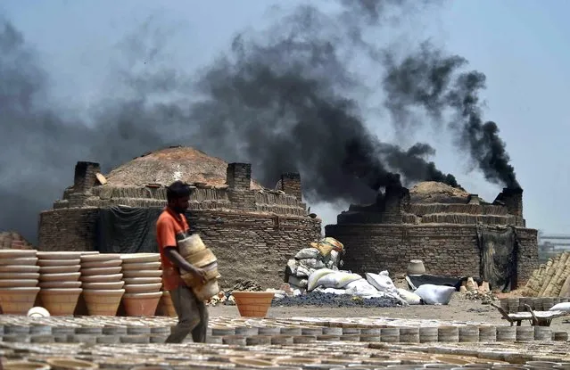 Smoke billows from a pottery kiln on the eve of the World Environment Day in Karachi, Pakistan, 04 June 2023. World Environment Day is celebrated annually on 05 June and aims to encourage awareness and environmental protection. (Photo by Shahzaib Akber/EPA/EFE)