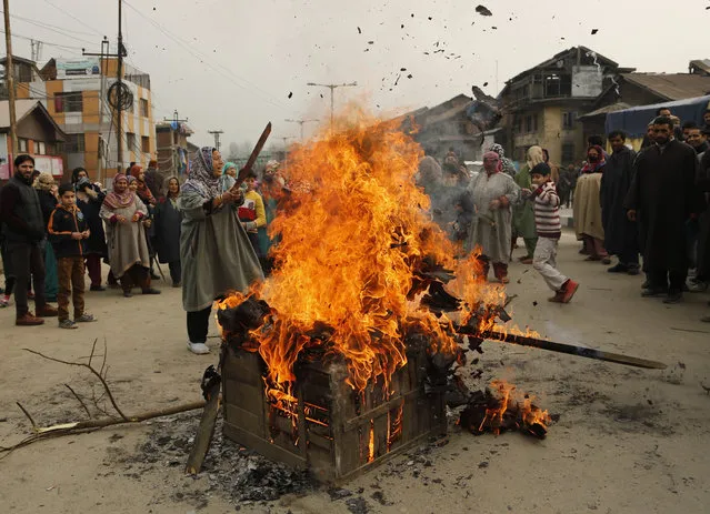 Kashmiri women burn a wooden box and tires to block a thoroughfare during a protest in Srinagar, India, Monday, December 14, 2015. The protest was held against an intended enforcement of food safety act which will limit the subsidised ration per person in the state to 5 kilos from the present 30 kilos. (Photo by Mukhtar Khan/AP Photo)