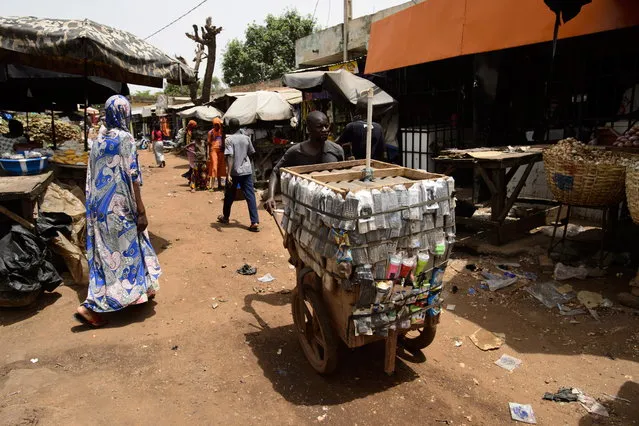 A man pushes a cart of electronics for sale through the streets of Bamako, Mali, Africa on Saturday, June 23, 2018. (Photo by Sean Kilpatrick/The Canadian Press via AP Photo)