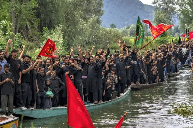 Kashmiri Shiite Muslims shout religious slogans as they participate in a Muharram procession on wooden boats in the interiors of Dal lake, on the outskirts of Srinagar, Indian controlled Kashmir, Friday, July 28, 2023. Muharram is a month of mourning in remembrance of the martyrdom of Imam Hussein, the grandson of Prophet Mohammed. (Photo by Dar Yasin/AP Photo)