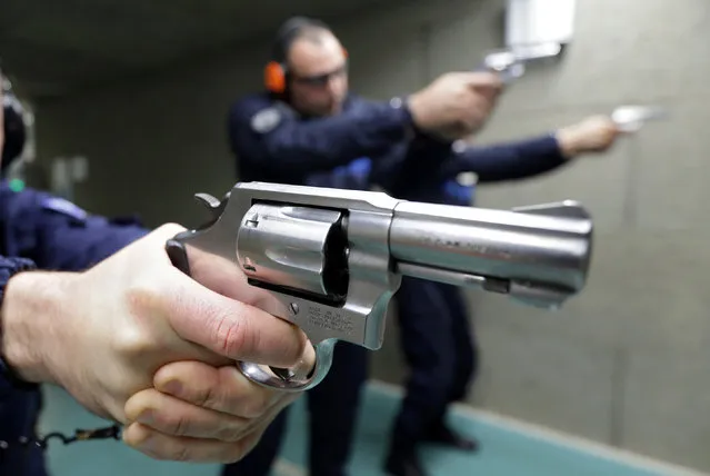 French municipal police officers from the city of Nice pose with revolvers during a target practice session in Nice, France, December 1, 2016. (Photo by Eric Gaillard/Reuters)