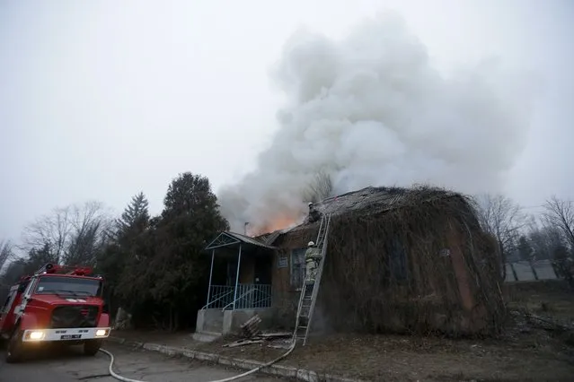 Firefighter try to extinguish a building on fire after shelling between Russian-backed separatists and Ukrainian government in residential area of the town of  Artemivsk, Ukraine, Saturday, February 14, 2015. (Photo by Petr David Josek/AP Photo)
