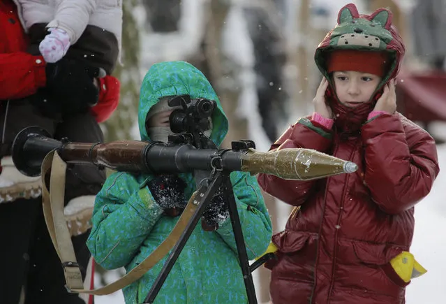 A boy aims an RPG at a weapons exhibition during a military show in St.Petersburg, Russia, Sunday, January 17, 2016. (Photo by Dmitry Lovetsky/AP Photo)