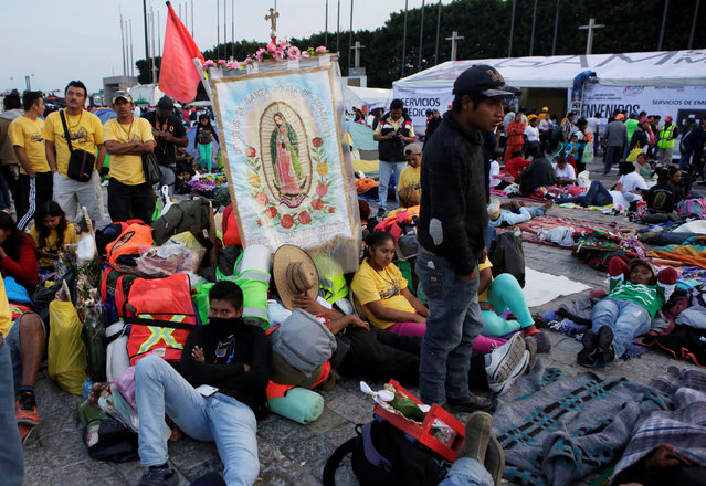 Pilgrims rest beside an image of the Virgin of Guadalupe at an improvised camp site at the Basilica of Guadalupe during the annual pilgrimage in honor of the Virgin of Guadalupe, patron saint of Mexican Catholics, in Mexico City, Mexico, December 11, 2016. (Photo by Henry Romero/Reuters)