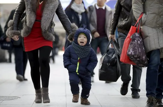 Ning Juyuan, 2.5 years old, and his parents arrive at Beijing Railway Station for their train to their hometown hometown Dalian of Liaoning province, in Beijing, China, January 25, 2016. (Photo by Jason Lee/Reuters)