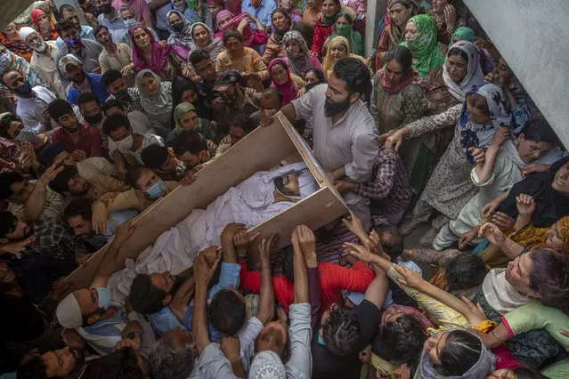 Relatives and neighbors lift the coffin of Waseem Ahmed, a policeman who was killed in a shootout, during his funeral on the outskirts of Srinagar, Indian controlled Kashmir, Sunday, June 13, 2021. Two civilians and two police officials were killed in an armed clash in Indian-controlled Kashmir on Saturday, police said, triggering anti-India protests who accused the police of targeting the civilians. (Photo by Dar Yasin/AP Photo)