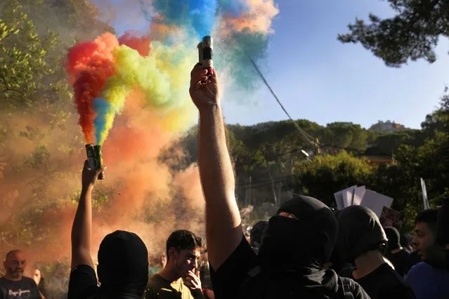 Lebanese-Armenian protesters hold flares with the colors of their nation's flag, near the Azerbaijani Embassy, to denounce the Azerbaijani military offensive that recaptured Nagorno-Karabakh from the separatist Armenian authorities in the enclave, in Ain Aar, east of Beirut, Lebanon, Thursday, September 28, 2023. (Photo by Hussein Malla/AP Photo)
