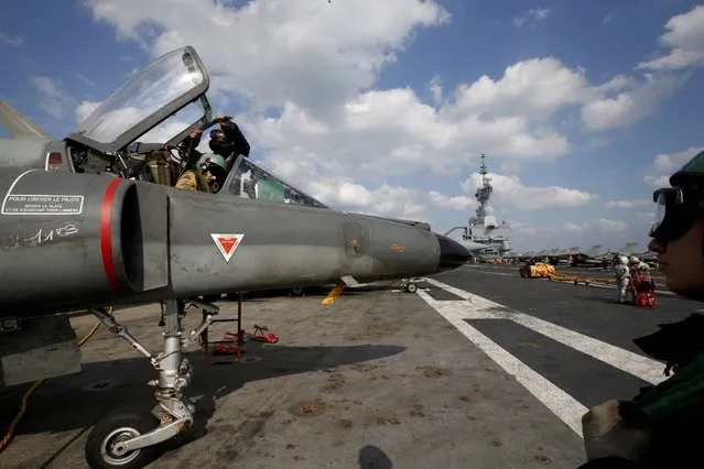 A pilot checks a Super Etendard fighter jet aboard France's Charles de Gaulle aircraft carrier prior to a mission in the Gulf, January 29, 2016. (Photo by Philippe Wojazer/Reuters)