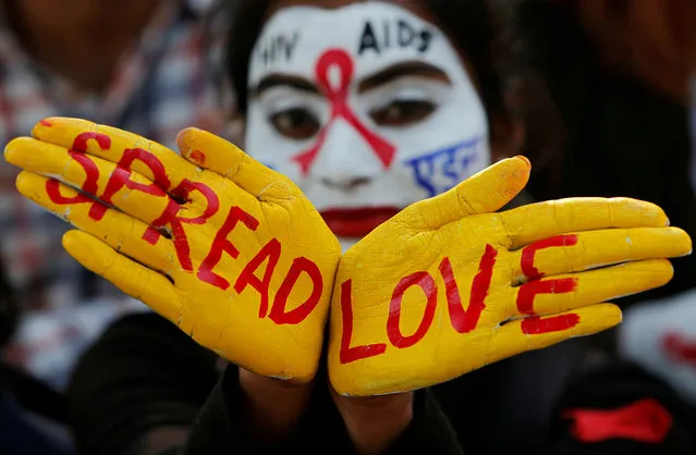 A student poses as she displays her face and hands painted with messages during an HIV/AIDS awareness campaign on the eve of World AIDS Day in Chandigarh, India, November 30, 2018. (Photo by Ajay Verma/Reuters)