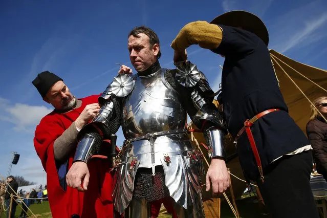 A reenactor is helped into his armour at the site of the Battle of Bosworth ahead of the arrival of Richard III's reburial procession, near Leicester, central England, March 22, 2015. Richard III's remains will be carried in procession through Leicestershire today on its way to the cathedral where they will be reburied. The body of Richard III, who died at the battle of Bosworth in 1485, was found under a supermarket car park in 2012. (Photo by Eddie Keogh/Reuters)