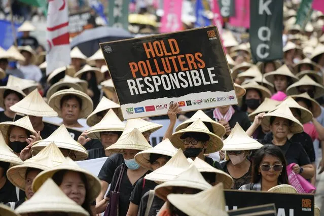 Protesters hold slogans as they join the global march to end fossil fuel on Friday, September 15, 2023, in Quezon city, Philippines. Tens of thousands of climate activists around the world are set to march, chant and protest Friday to call for an end to the burning of planet-warming fossil fuels as the globe continues to suffer dramatic weather extremes and topple heat records. (Photo by Aaron Favila/AP Photo)