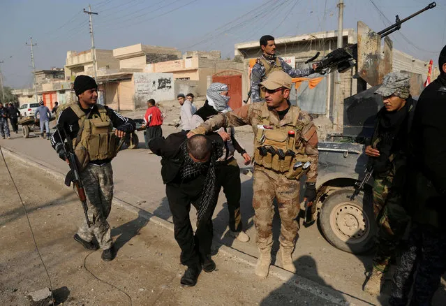 Iraqi security forces arrest a suspected fighter with the Islamic State group during a military operation to regain control of the eastern side of Mosul, Iraq, Wednesday, January 4, 2017. (Photo by Khalid Mohammed/AP Photo)