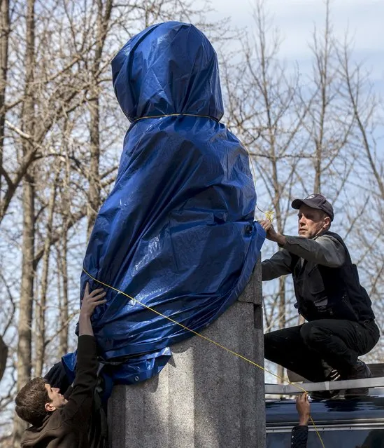 New York City Parks workers work to remove a large molded bust of Edward Snowden in Fort Greene Park at the Brooklyn borough of New York April 6, 2015. A group of anonymous artists erected a 4-foot-tall bronze statue of Edward Snowden, the former U.S. spy agency contractor famous for leaking classified information, in a New York City park overnight, officials said on Monday. (Photo by Brendan McDermid/Reuters)