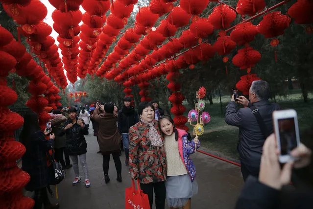 People have their pictures taken under red lanterns as the Chinese Lunar New Year, which welcomes the Year of the Monkey, is celebrated at the temple fair at Ditan Park (the Temple of Earth), in Beijing, China February 11, 2016. (Photo by Damir Sagolj/Reuters)