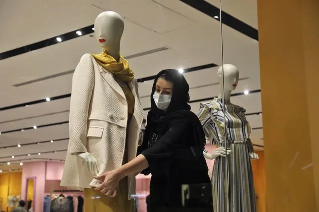 A shopkeeper adjusts a jacket on a mannequin at Iran Mall shopping center in Tehran, Iran, Wednesday, June 9, 2021. The West considers Iran's nuclear program and Mideast tensions as the most important issues facing Tehran, but those living in the Islamic Republic repeatedly point to the economy as the major issue facing it ahead of its June 18 presidential election. (Photo by Vahid Salemi/AP Photo)