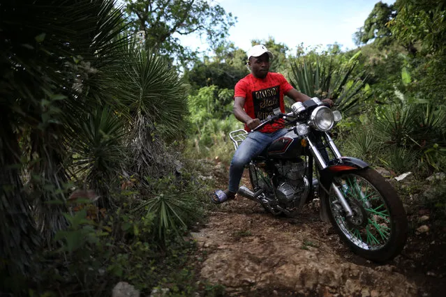 A man rides a motorbike across the trail that connects Boucan Ferdinand with the border between Haiti and Dominican Republic, on the outskirts of Boucan Ferdinand, Haiti, April 8, 2018. (Photo by Andres Martinez Casares/Reuters)