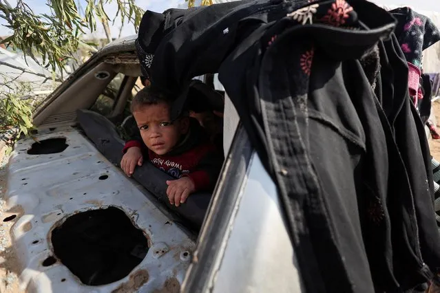 A Palestinian child looks on, as displaced Palestinians, who fled their houses due to Israeli strikes, shelter in a tent camp, amid the ongoing conflict between Israel and the Palestinian Islamist group Hamas, in Rafah in the southern Gaza Strip on December 8, 2023. (Photo by Ibraheem Abu Mustafa/Reuters)