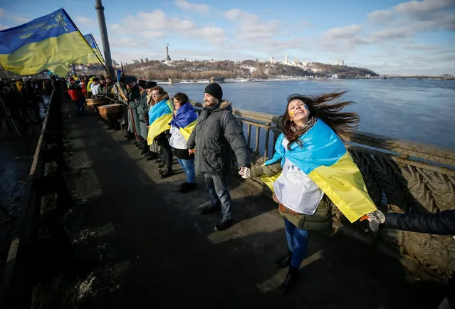 People stand on a bridge while forming a human chain across the Dnipro River during celebrations for Unity Day in Kiev, Ukraine, January 22, 2017. (Photo by Gleb Garanich/Reuters)