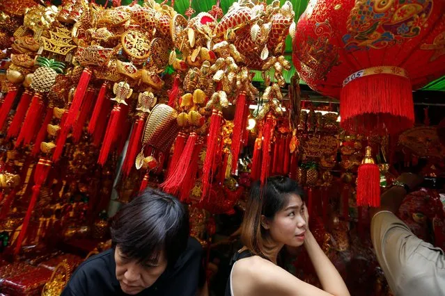 Costumers are seen inside a decorations shop ahead of the upcoming Year of the Rooster celebrations in Chinatown, Bangkok, Thailand January 25, 2017. (Photo by Jorge Silva/Reuters)