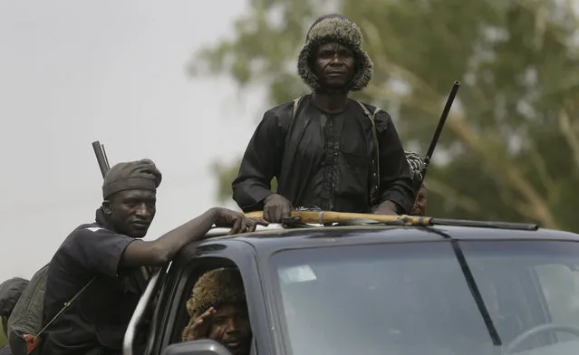 Vigilantes and local hunters armed with locally made guns patrol on the street near the Independent National Electoral Commission office in Yola, Nigeria, Monday February 25, 2019. (Photo by Sunday Alamba/AP Photo)