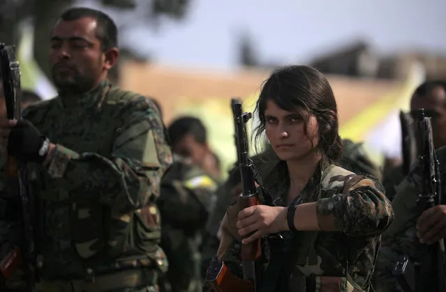 A fighter of Syrian Democratic Forces (SDF) holds her weapon as they announce the destruction of Islamic State's control of land in eastern Syria, at al-Omar oil field in Deir Al Zor, Syria on March 23, 2019. (Photo by Rodi Said/Reuters)