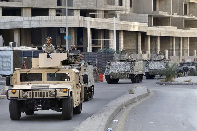 Lebanese army soldiers on armed vehicles patrol at the site where deadly clashes that erupted Thursday along a former 1975-90 civil war front-line between Muslim Shiite and Christian areas, in Ain el-Remaneh neighborhood, Beirut, Lebanon, Friday, October 15, 2021. (Photo by Bilal Hussein/AP Photo)