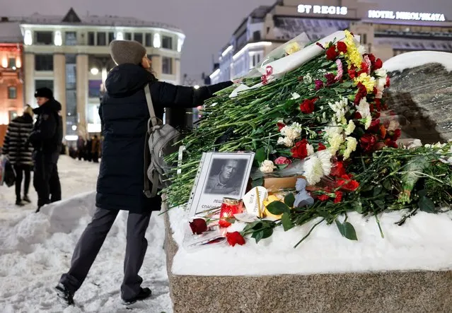 A woman lays flowers at the monument to the victims of political repressions following the death of Russian opposition leader Alexei Navalny, in Moscow, Russia on February 16, 2024. (Photo by Reuters/Stringer)