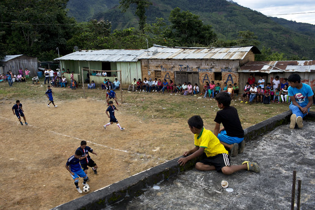 In this March 15, 2015 photo, young men compete in a multi-village soccer tournament, in La Mar, province of Ayacucho, Peru. A hardy lot, cocaine backpackers are mostly native Quechua speakers and hail from the isolated communities that suffered the worst atrocities of Peru's 1980-2000 dirty war with Shining Path rebels. (Photo by Rodrigo Abd/AP Photo)