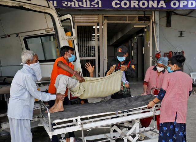 Jagdishbhai Himmatbhai Solanki, with a breathing problem, is wheeled inside a COVID-19 hospital for treatment during the ongoing coronavirus disease (COVID-19) outbreak in Ahmedabad, India, November 23, 2021. (Photo by Amit Dave/Reuters)