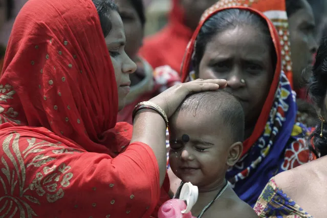 A woman wets the head of a child during an election rally addressed by Trinamool Congress leader and Chief Minister of West Bengal state Mamata Banerjee at Anchana in Mathurapur, about 60 kilometers south of Kolkata, India, Thursday, May 16, 2019. With 900 million of India's 1.3 billion people registered to vote, the Indian national election is the world's largest democratic exercise. The seventh and last phase of the elections will be held on Sunday. (Photo by Bikas Das/AP Photo)