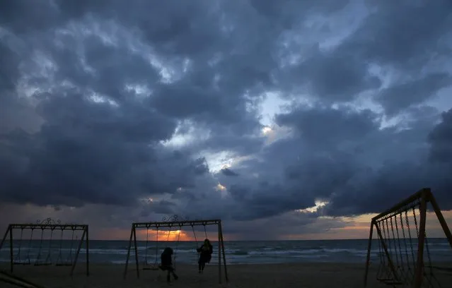 Women sit on a swing at the seaside of Ramlet al-Bayda beach as storm clouds loom during sunset in Beirut, Lebanon January 23, 2016. (Photo by Jamal Saidi/Reuters)