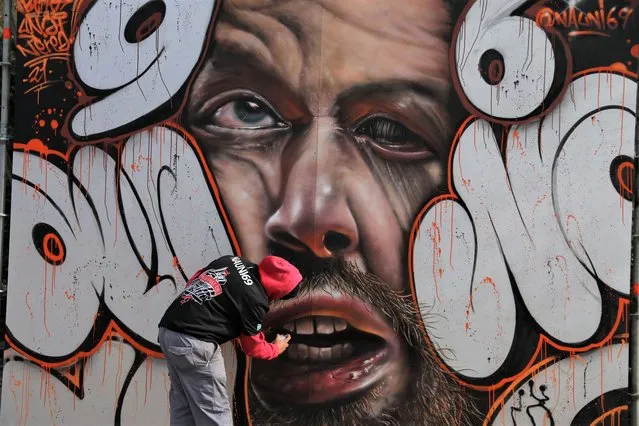 Graffiti artist Nauni69 gives the finishing touch to a mural during the Final of the National Graffiti League, at El Retiro Park on November 28, 2021 in Madrid, Spain. (Photo by Isabel Infantes/Getty Images)