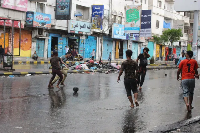 Yemen youths play soccer in the rain on a street in Taiz city, Yemen, Sunday, May 17, 2015. (Photo by Abdulnasser Alseddik/AP Photo)